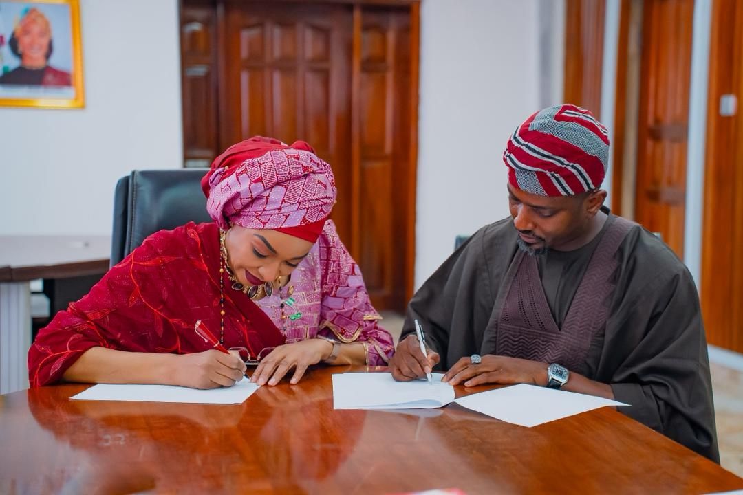 Two people signing documents, from the original MakeItNaija website